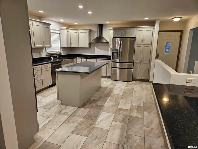 a kitchen with stainless steel appliances granite countertop a sink a stove a refrigerator and cabinets