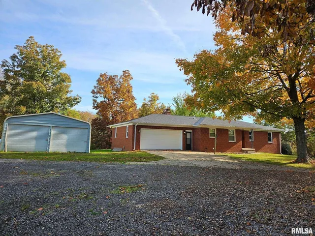 a view of a house with a yard and large trees