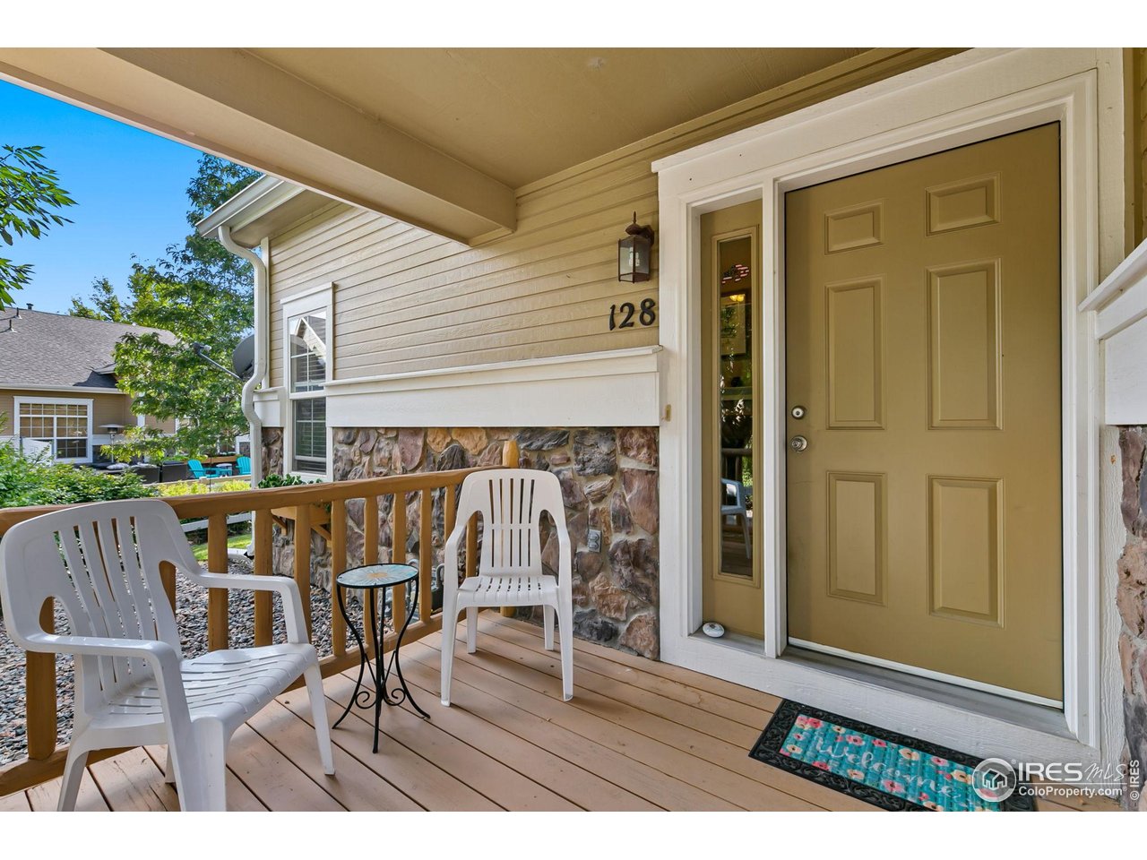 128 Bayside Circle Windsor, CO 80550 - Photo 2 of 24 a view of a patio with table and chairs with wooden floor and fence