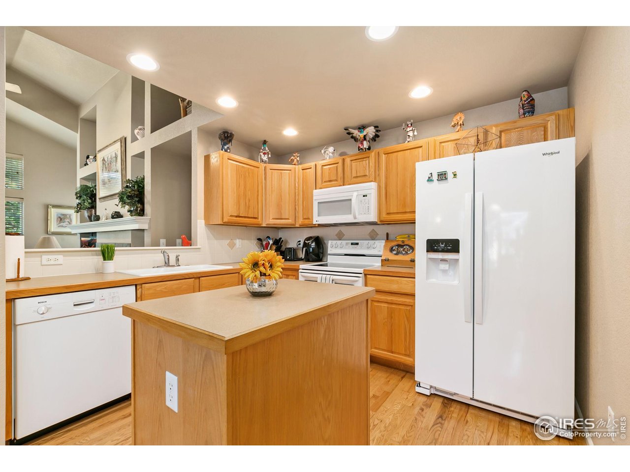 128 Bayside Circle Windsor, CO 80550 - Photo 7 of 24 a kitchen with a refrigerator a sink and cabinets