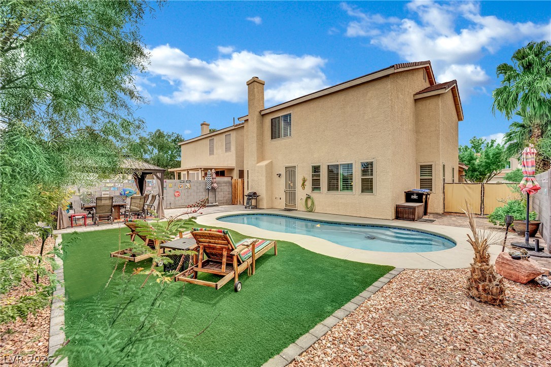 1724 Millstream Way Henderson, NV 89074 - Photo 36 of 60 A private backyard oasis features an inviting in-ground pool, turf area, and desert landscaping.