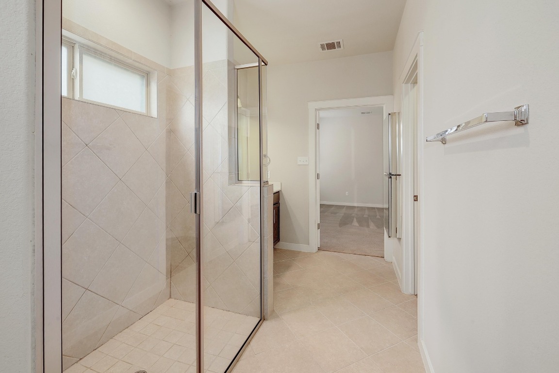 16233 Travesia Way Austin, TX 78728 - Photo 15 of 27 a bathroom with a shower and a glass door