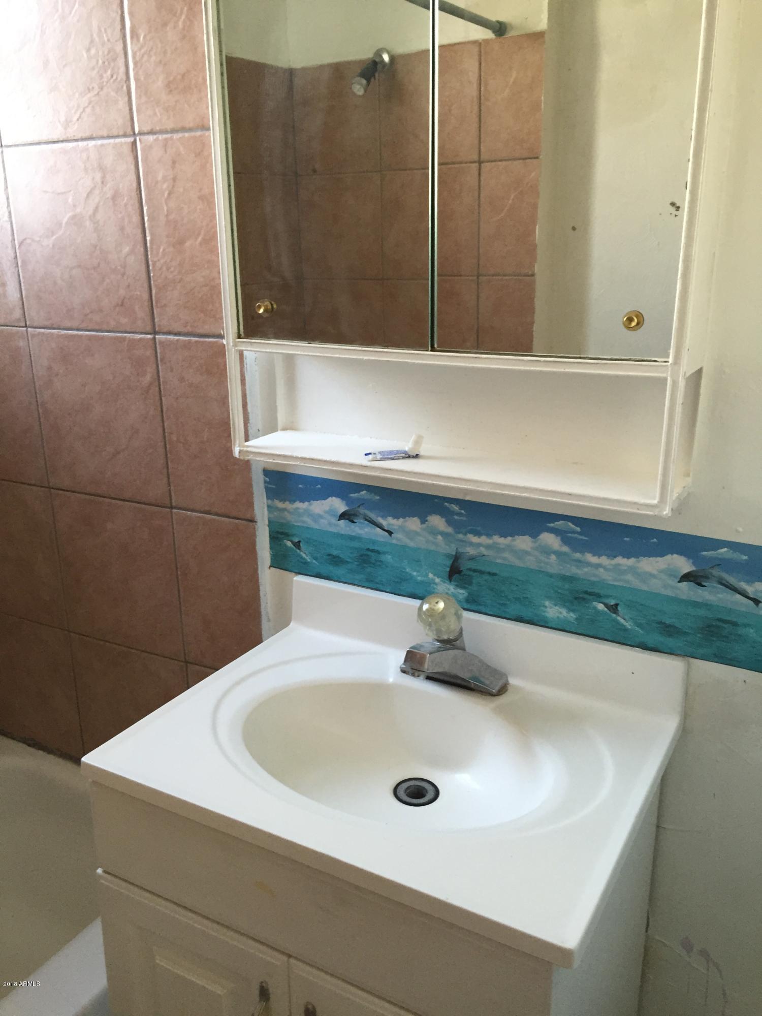 1165 East 10th Street Douglas, AZ 85607 - Photo 11 of 54 a bathroom with a sink and a mirror