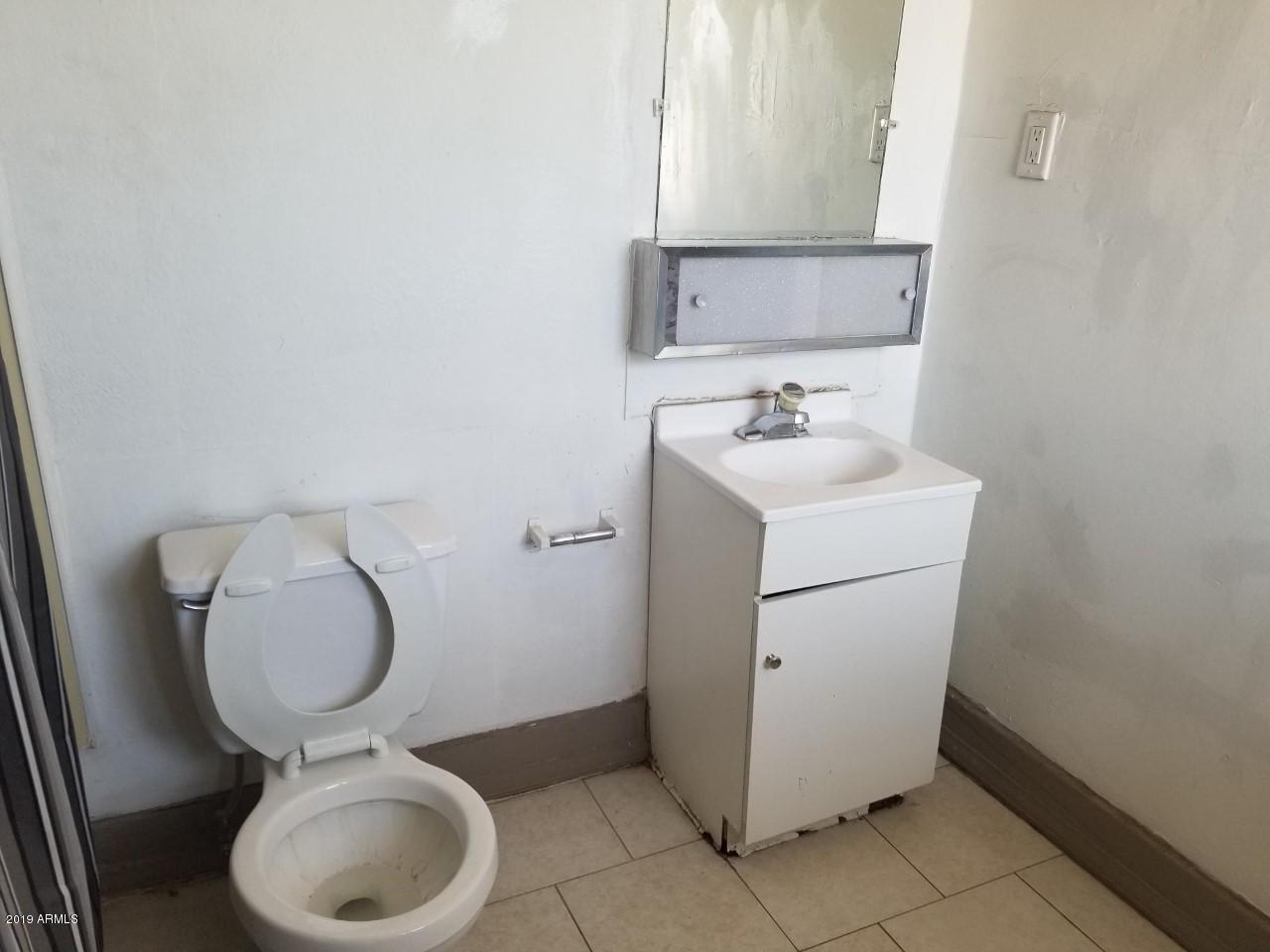 1165 East 10th Street Douglas, AZ 85607 - Photo 21 of 54 a bathroom with a toilet sink and mirror