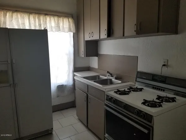 a view of an empty room with a kitchen