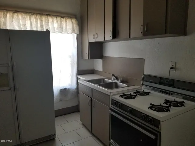 a view of an empty room with a kitchen