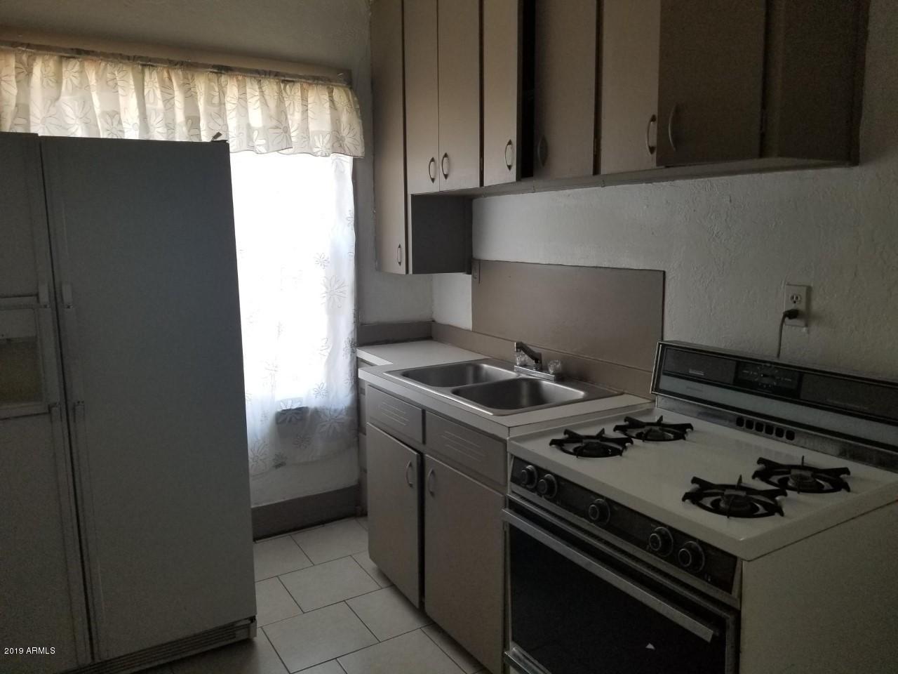 1165 East 10th Street Douglas, AZ 85607 - Photo 23 of 54 a kitchen with a stove and a refrigerator