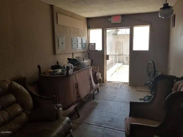 a hallway with wooden floor chandelier and livingroom view