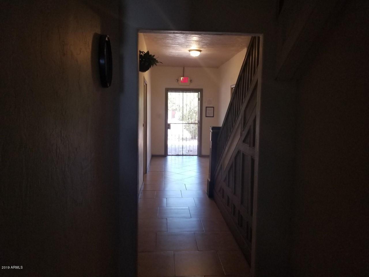1165 East 10th Street Douglas, AZ 85607 - Photo 38 of 54 a hallway with wooden floor chandelier and livingroom view
