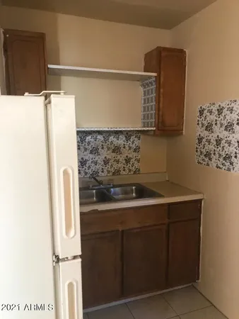 a living room with stainless steel appliances kitchen island granite countertop furniture and a refrigerator