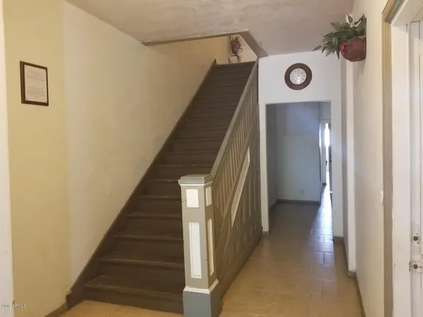a view of a hallway with wooden floor and entryway