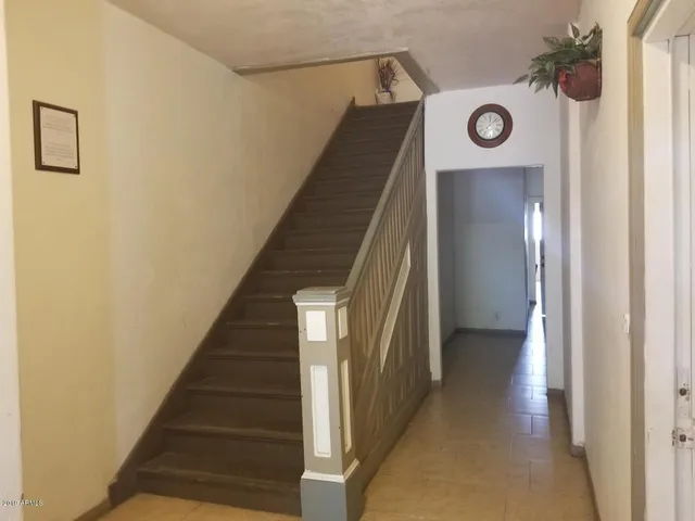 a view of a hallway with wooden floor and entryway