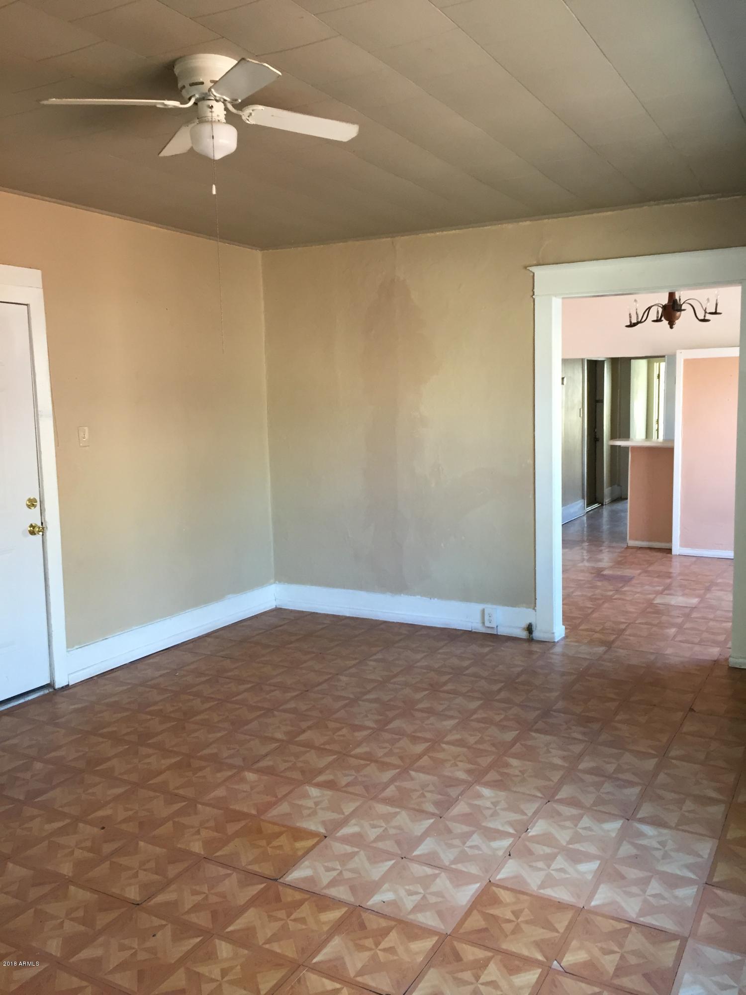 1165 East 10th Street Douglas, AZ 85607 - Photo 7 of 54 a view of a livingroom with a chandelier fan and wooden floor