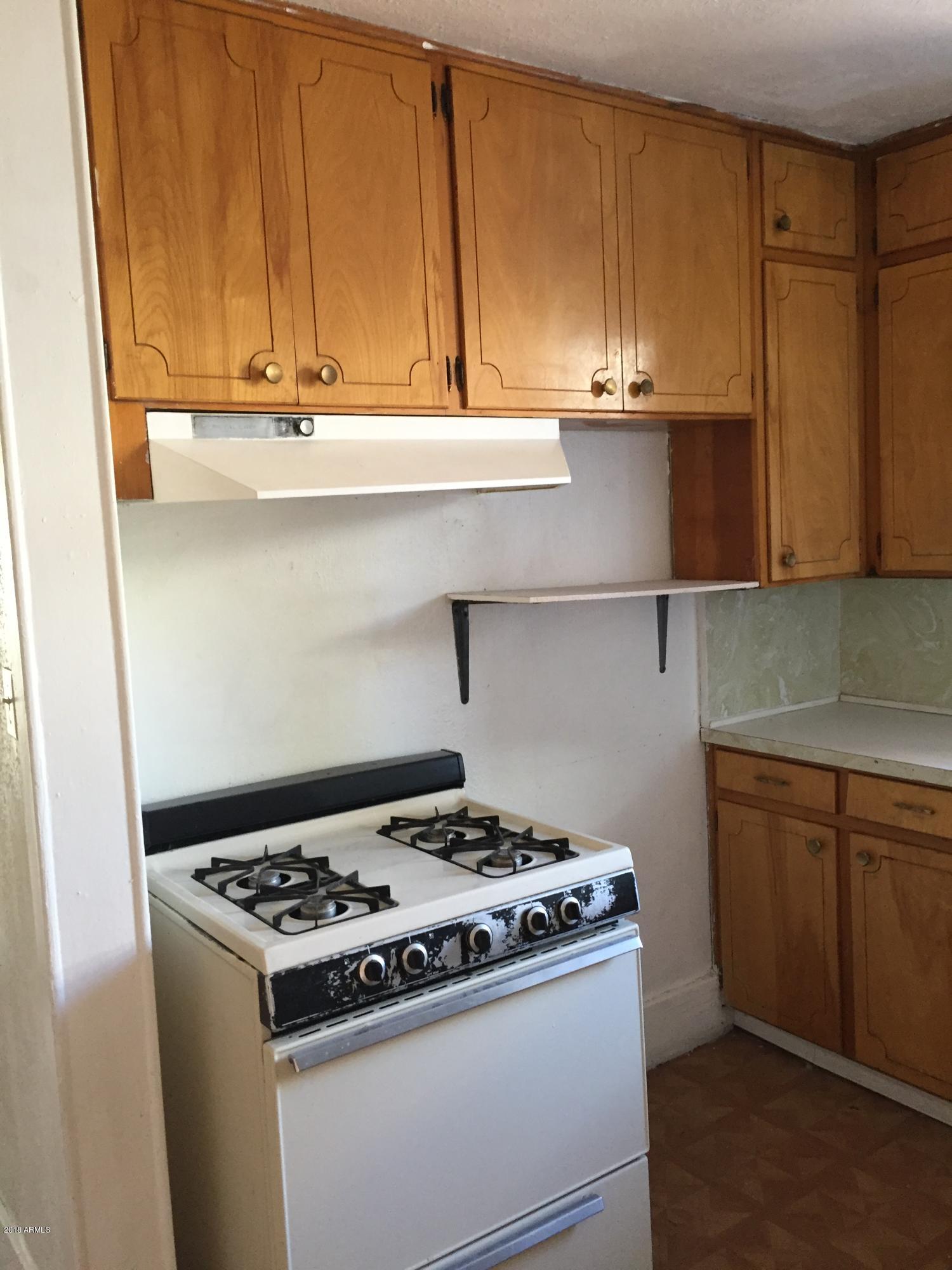 1165 East 10th Street Douglas, AZ 85607 - Photo 9 of 54 a kitchen with a stove and a cabinets