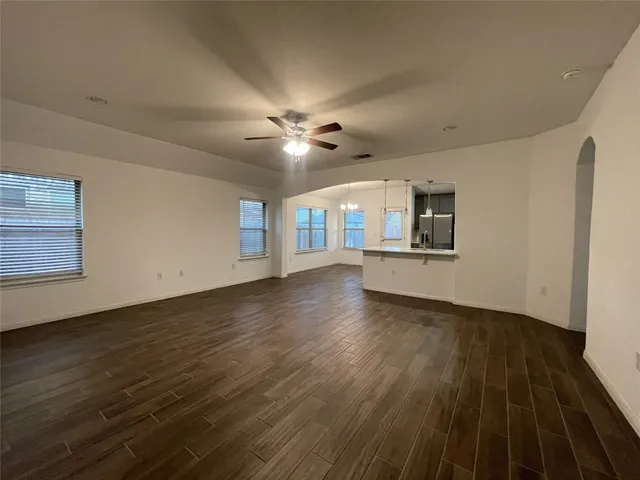a view of a livingroom with wooden floor and a ceiling fan