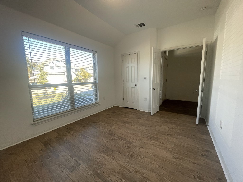 308 Somerville Street Leander, TX 78641 - Photo 7 of 24 Unfurnished bedroom featuring lofted ceiling, dark wood-style flooring, and a closet