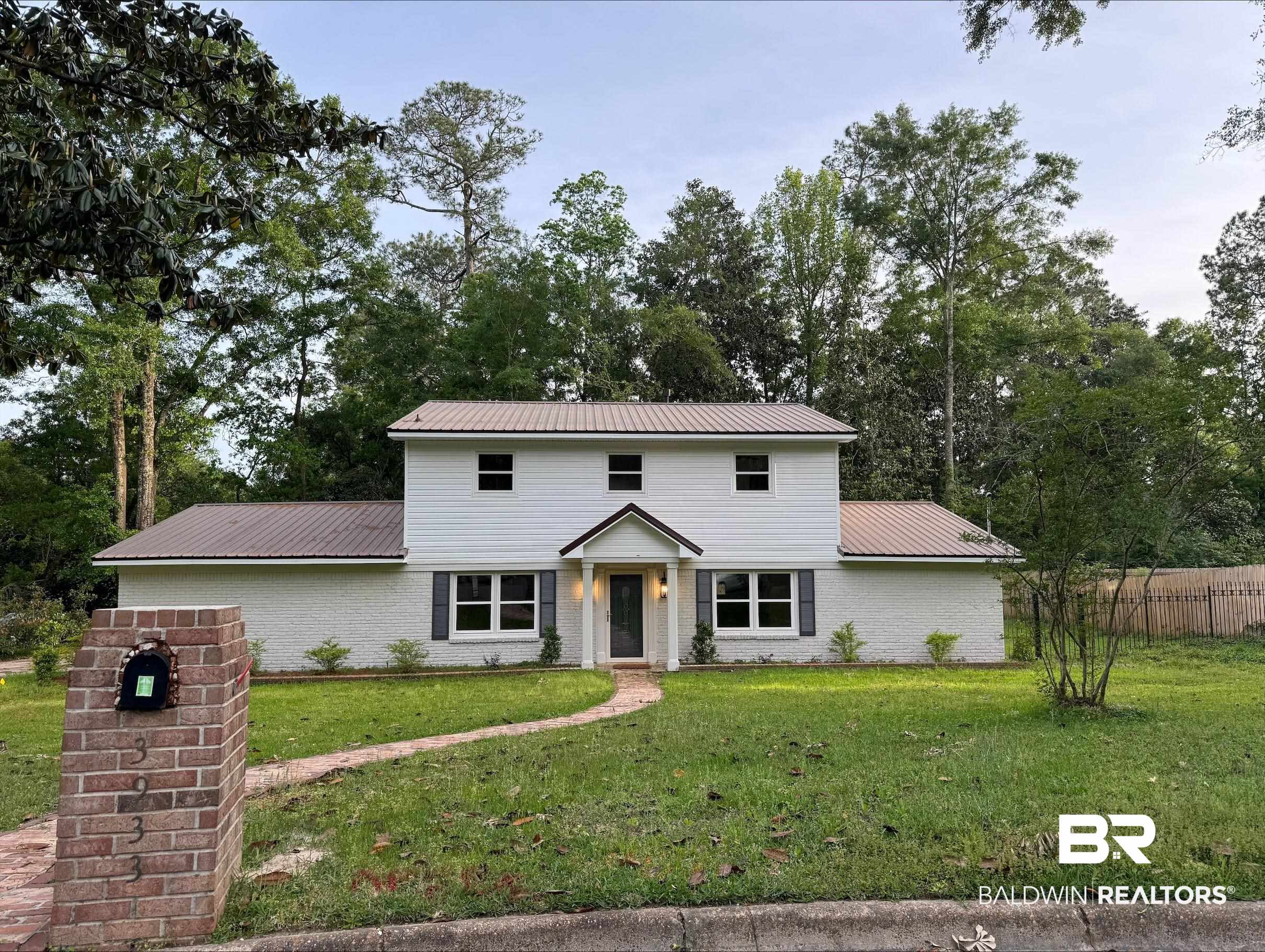 3933 Radnor Avenue Mobile, AL 36608 - Photo 32 of 36 Colonial-style house with a metal roof, brick siding, and view of wooded area