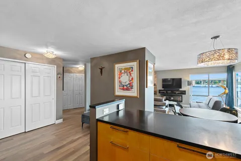 a view of a kitchen counter top space with stainless steel appliances wooden floor and chair