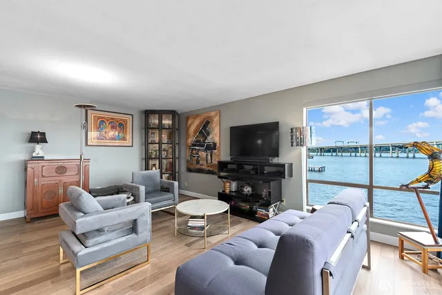 a living room with furniture a flat screen tv and a large window