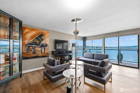 a living room with furniture a flat screen tv and a large window