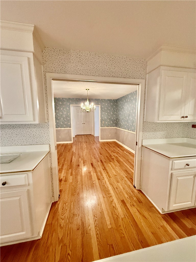 235 Stonehaven Way Seneca, SC 29672 - Photo 20 of 35 A well-lit interior showcases gleaming hardwood flooring and a classic chandelier, offering a seamless flow between rooms.