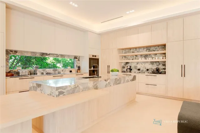 a large white kitchen with stainless steel appliances cabinets and a counter top space