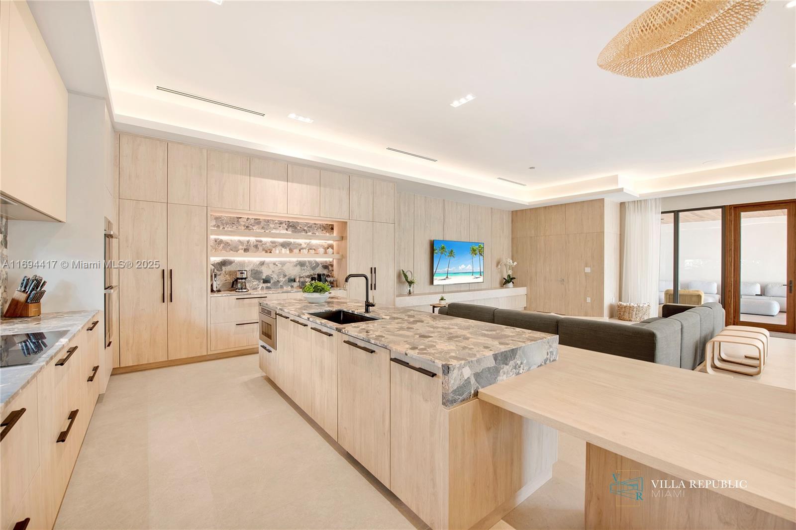 1200 Northeast 87th Street Miami, FL 33138 - Photo 13 of 58 a large kitchen with kitchen island a stove a sink a refrigerator and white cabinets with wooden floor