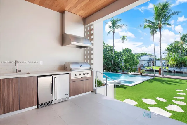 a kitchen with kitchen island a stove a sink and a living room view