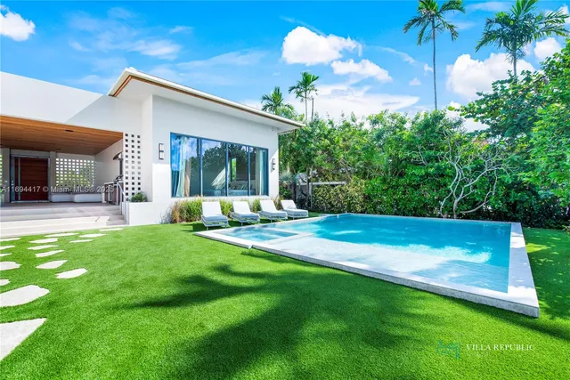 a large white bed sitting in a room next to a window