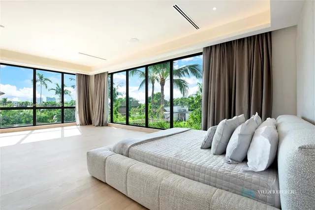 a bedroom with a bed and a large window