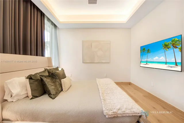 a bedroom with a large bed and a painting on the wall