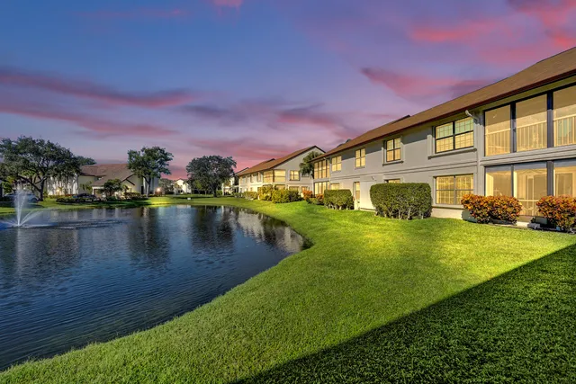 a front view of a house with a yard and potted plants