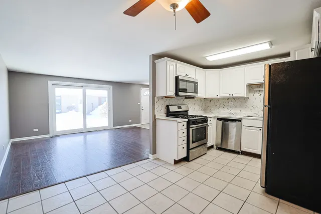 a kitchen with granite countertop a refrigerator stove top oven and sink