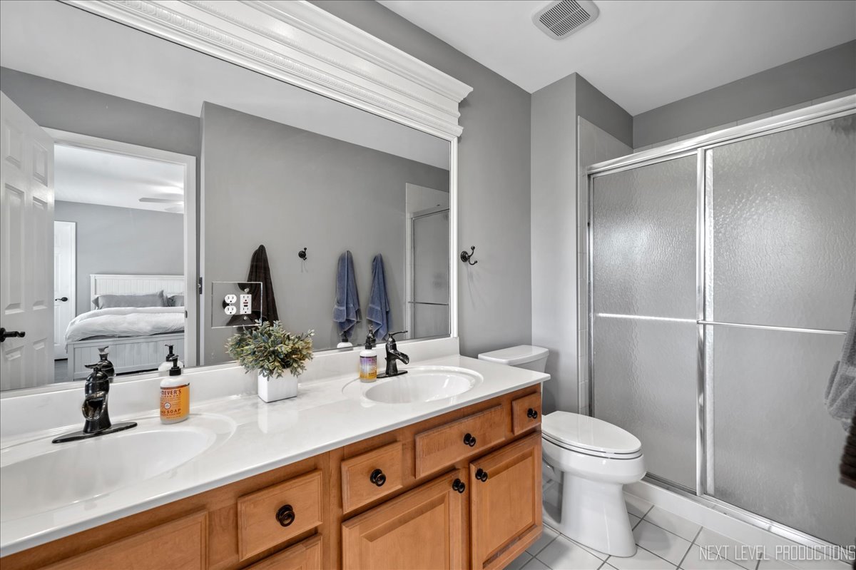 39W252 Bartelt Road Geneva, IL 60134 - Photo 17 of 34 a bathroom with a double vanity sink toilet and shower