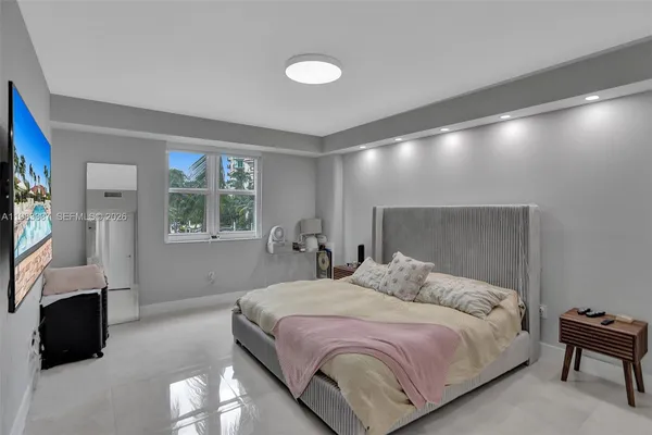 a bedroom with a bed and a flat screen tv