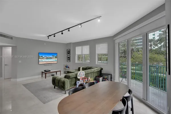 a living room with furniture two large windows and a flat screen tv