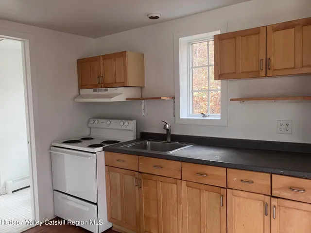 a kitchen with granite countertop a sink stove and cabinets