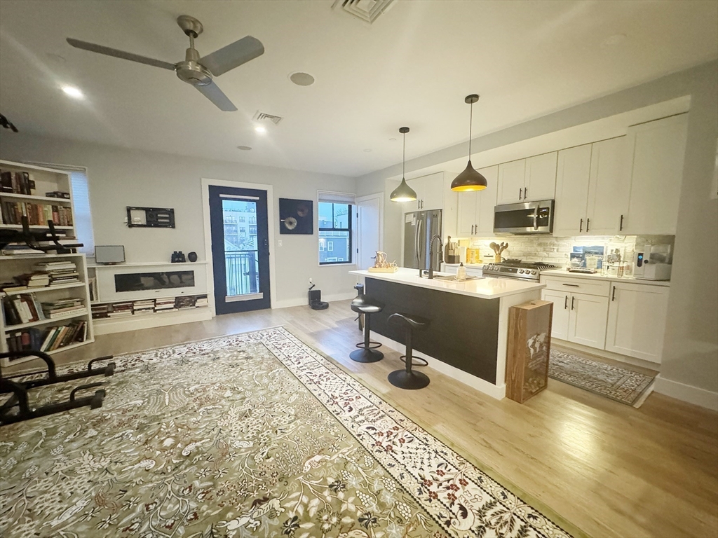 278 Sumner Street, Unit PH Boston, MA 02128 - Photo 2 of 20 a kitchen with stainless steel appliances granite countertop a sink stove and refrigerator