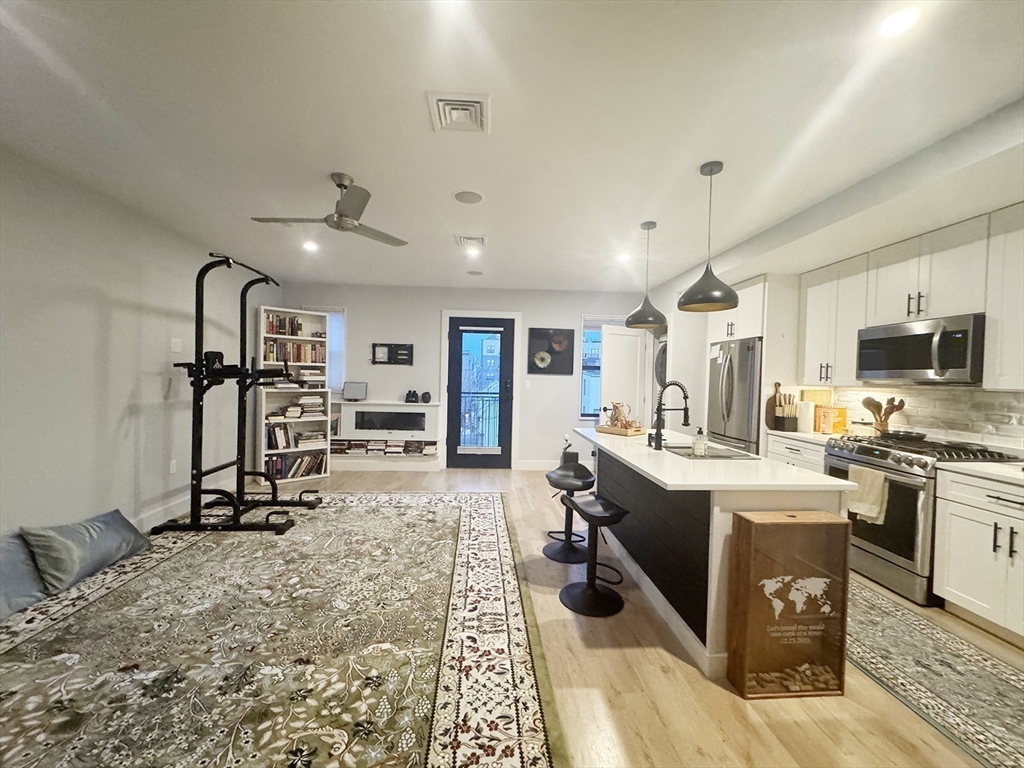 278 Sumner Street, Unit PH Boston, MA 02128 - Photo 8 of 20 a view of a kitchen with kitchen island stainless steel appliances refrigerator stove microwave and cabinets
