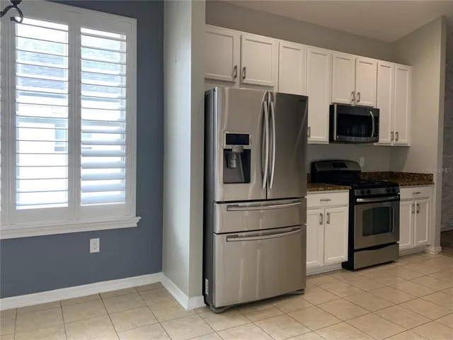 a view of a kitchen with dishwasher and white cabinets