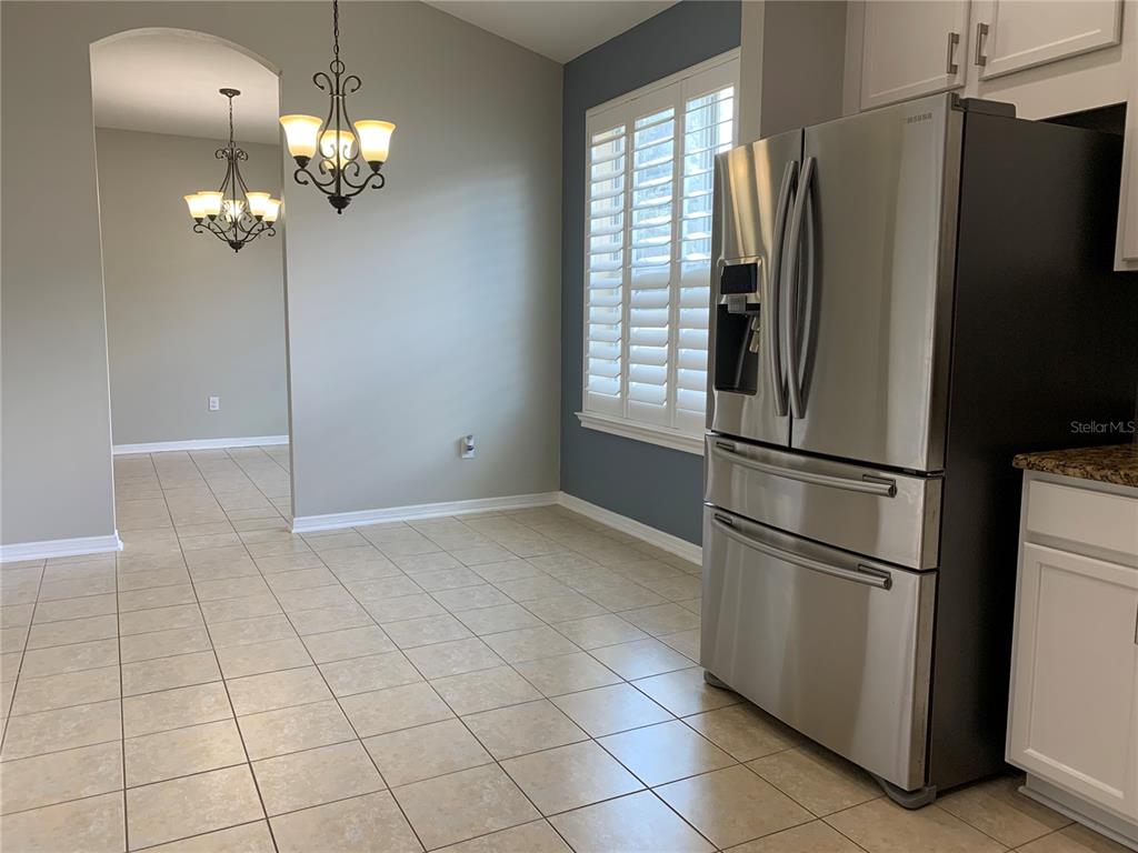 10308 Holland Road Riverview, FL 33578 - Photo 14 of 66 a kitchen with stainless steel appliances granite countertop a refrigerator and a chandelier
