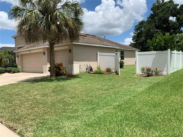 a front view of a house with a yard and trees