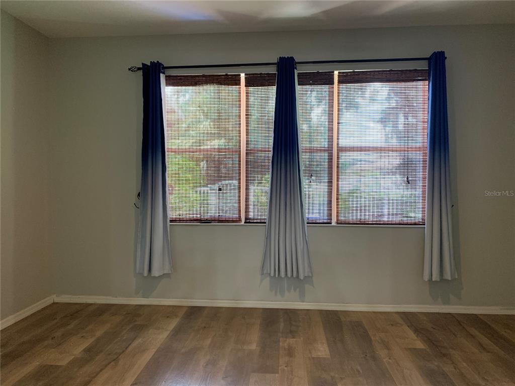 10308 Holland Road Riverview, FL 33578 - Photo 32 of 66 a view of an empty room with wooden floor and a window