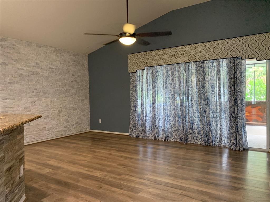 10308 Holland Road Riverview, FL 33578 - Photo 41 of 66 an empty room with wooden floor chandelier fan and windows
