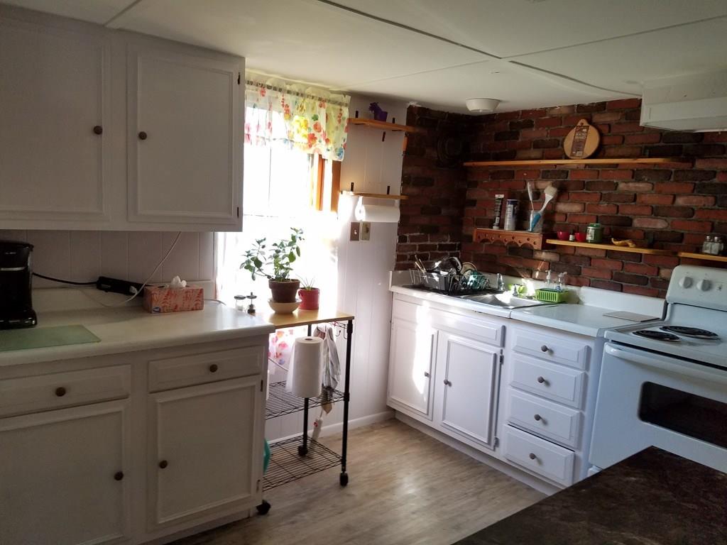 298 Deerfield Street Greenfield, MA 01301 - Photo 5 of 13 a kitchen with white cabinets and white appliances
