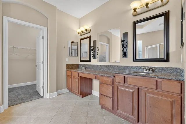 a bathroom with a granite countertop sink two mirror and a