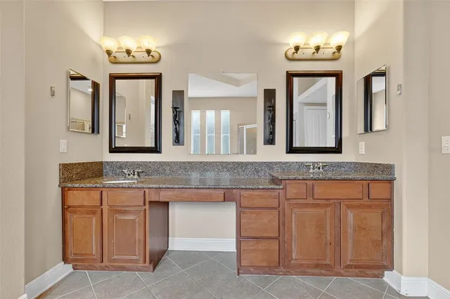 a bathroom with a granite countertop sink and a mirror