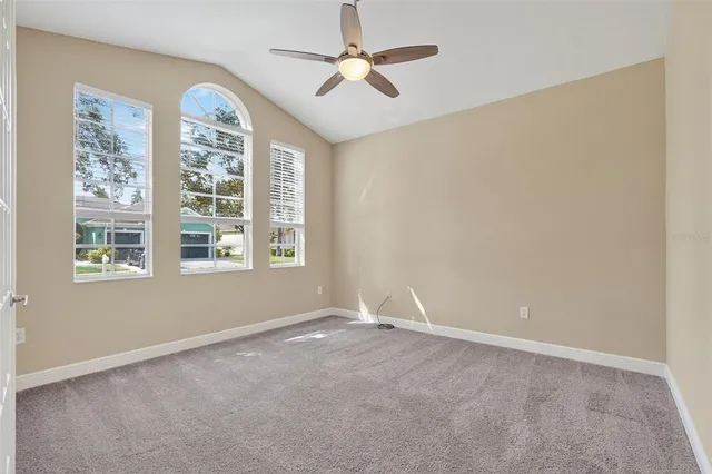 an empty room with windows and fan