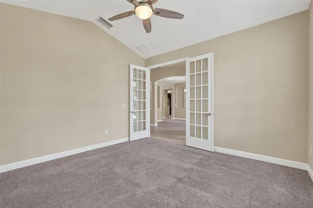 a view of an empty room with a chandelier fan