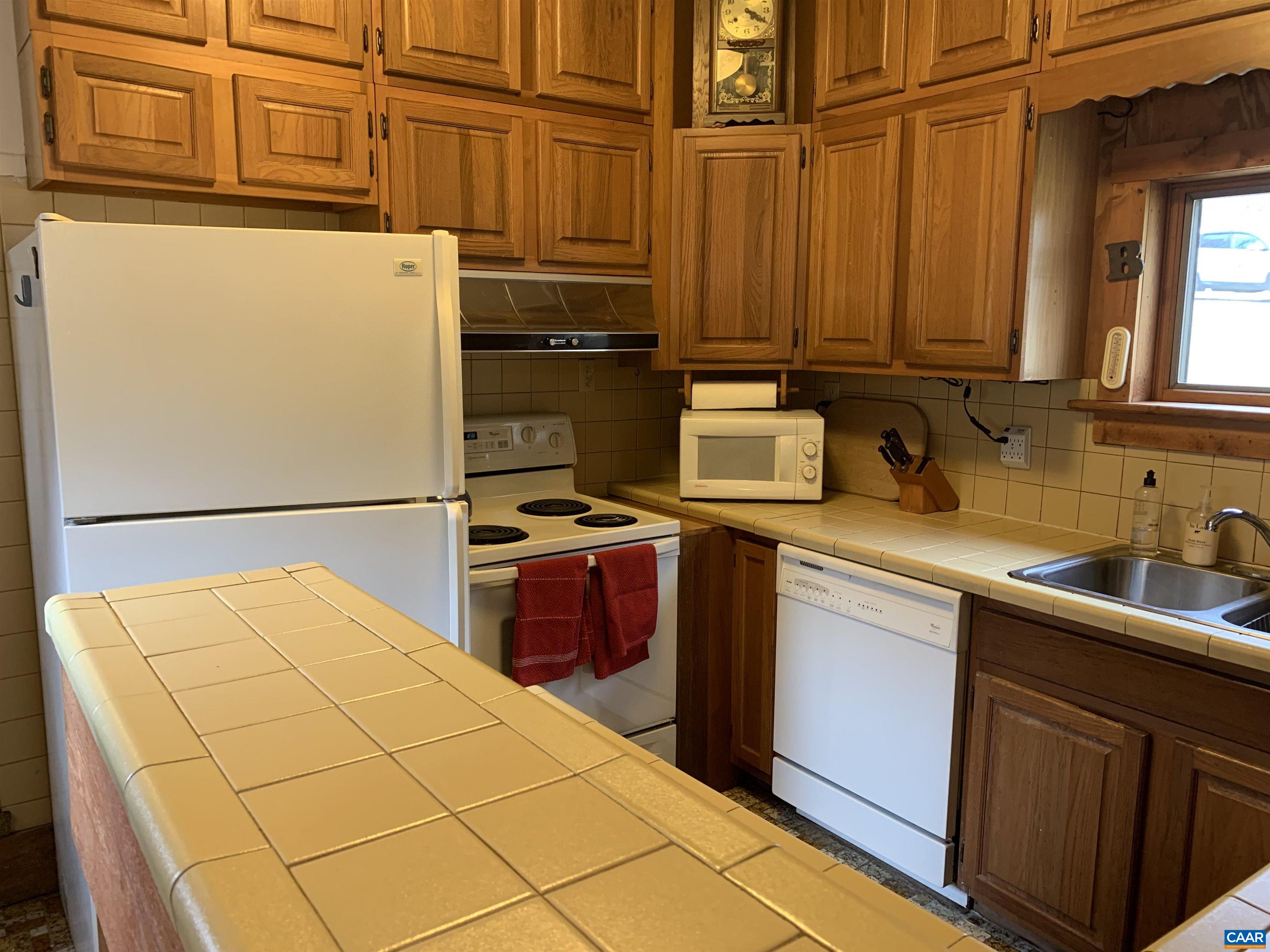 4873 Weakley Hollow Road Syria, VA 22743 - Photo 16 of 38 a kitchen with stainless steel appliances a refrigerator sink and cabinets